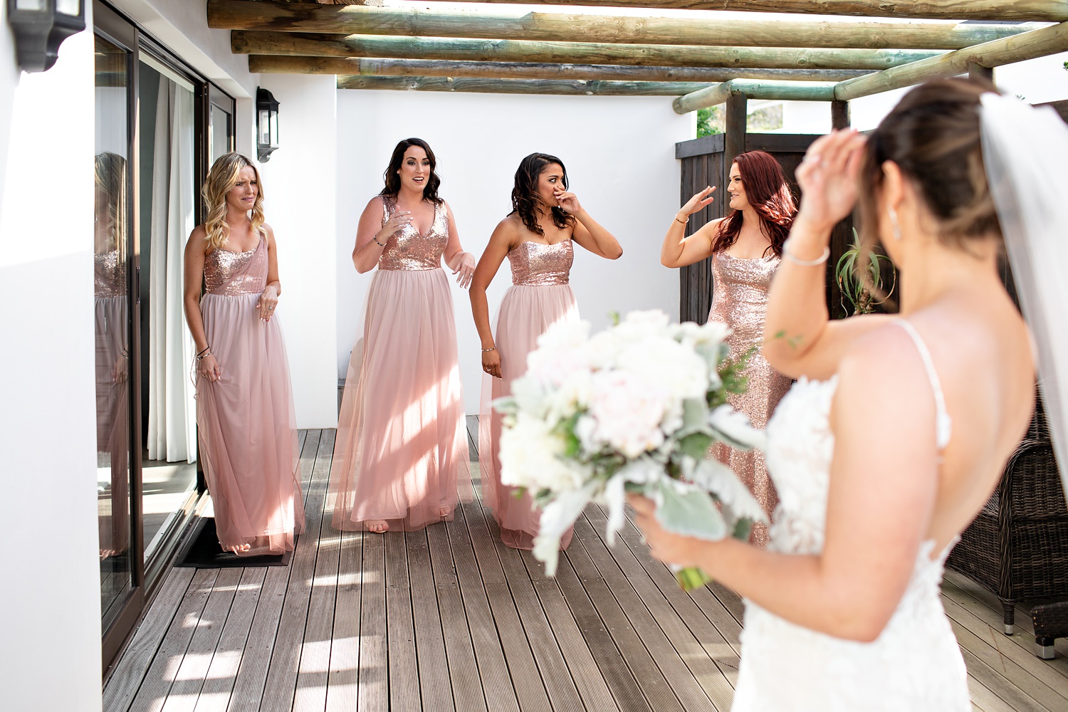 The bride has a first look with her bridesmaids and their reaction is priceless as they all start crying