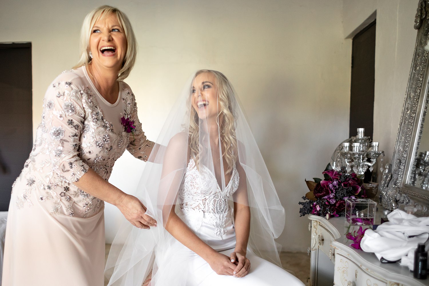 Precious mom and daughter moment at a wedding after she has placed the veil over the bride's head.
