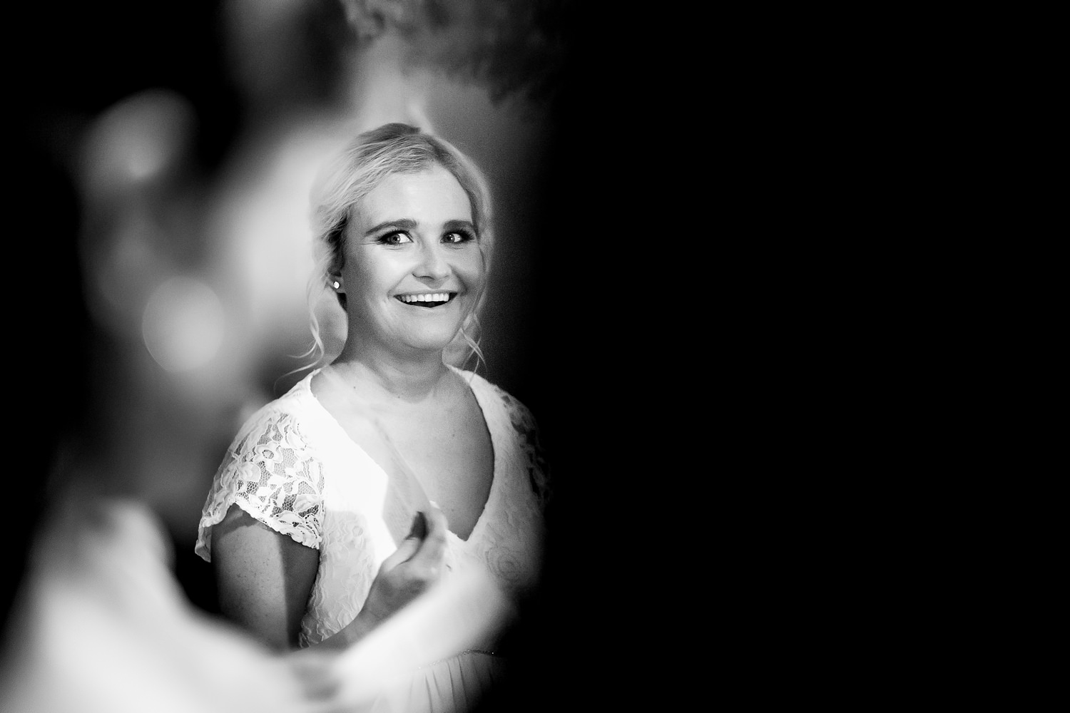The bride looks at her bridesmaids with a huge smile on her face during a hymn by wedding photographer in South Africa, Niki M Photography