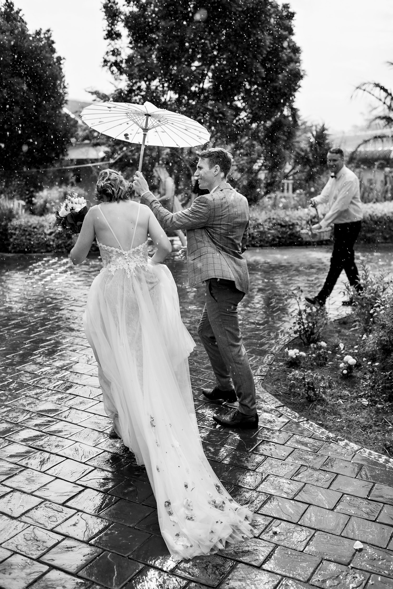 Beautiful candid and real moment of the bride and groom who had rain on their wedding day by wedding photographer in South Africa, Niki M Photography