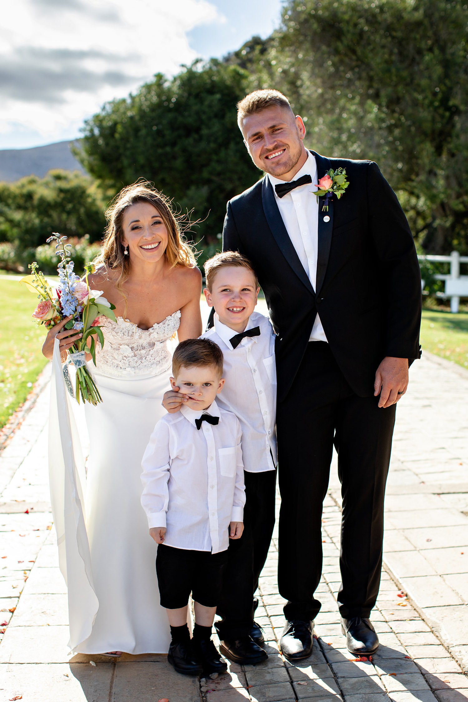 The bride and groom pose for a funny photograph with ring bearers at Blomfontein wedding venue near Cradock by wedding photographer in South Africa, Niki M Photography