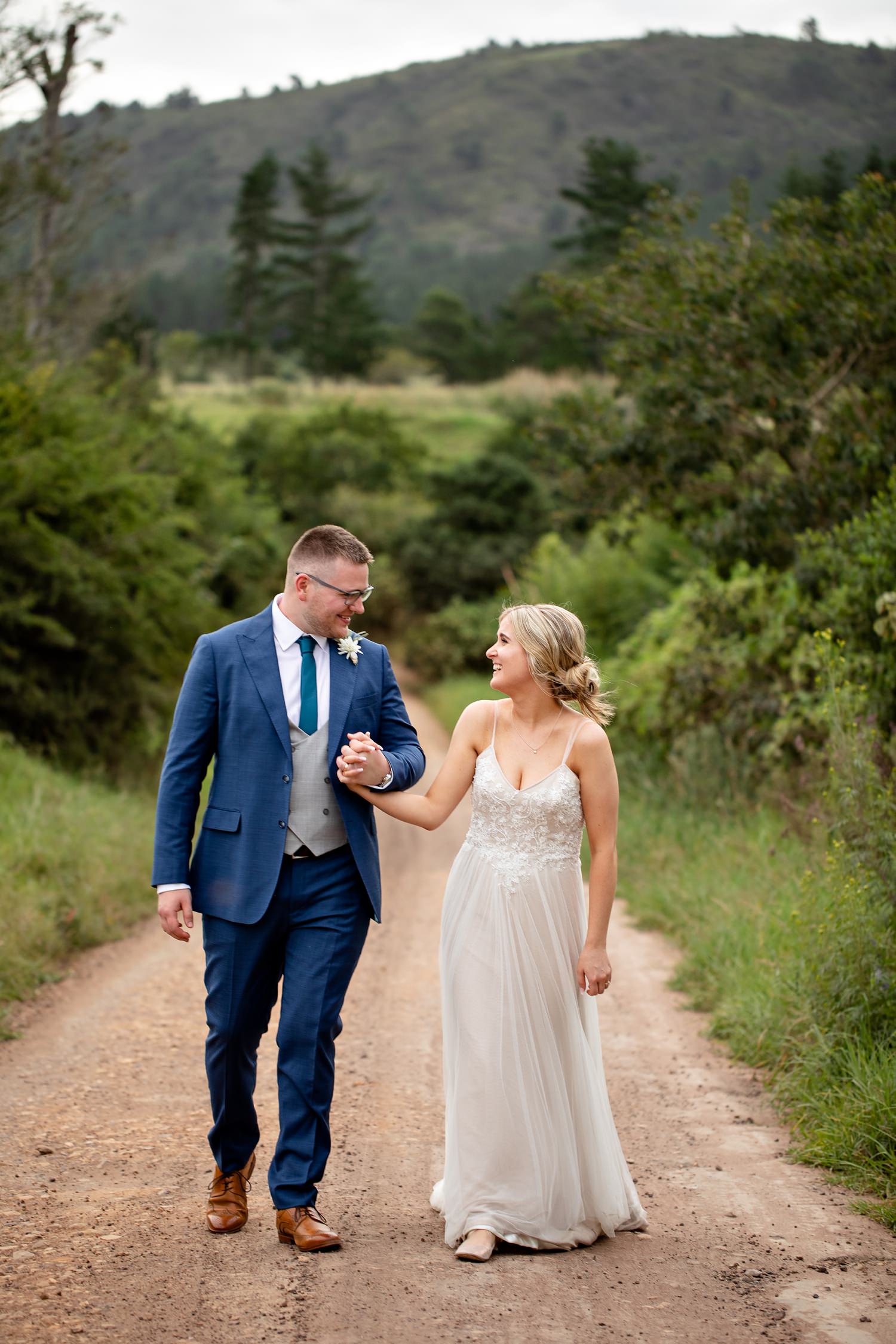 Real laughter and real moments between the bride and groom during their couple photo session on a farm road