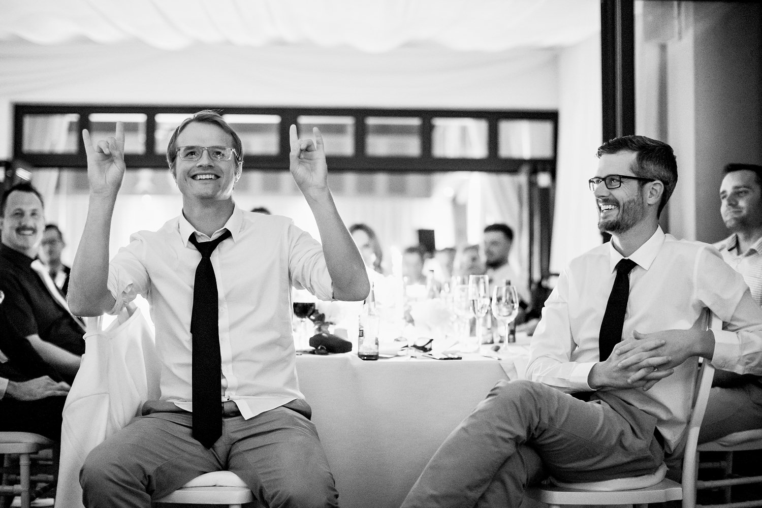 A wedding guest gestures the groom during his speech