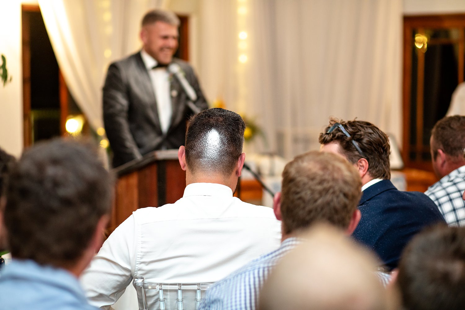 Funny moment caught on camera during the wedding reception as a guest has the back of his head sprayed with white spray