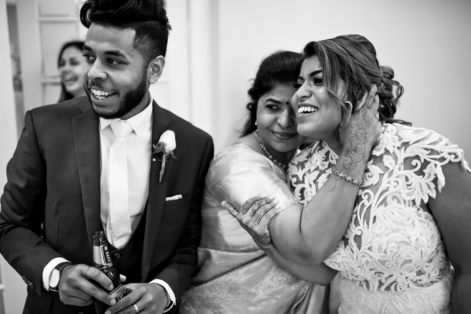 Mother of the bride embraces her daughter as they laugh