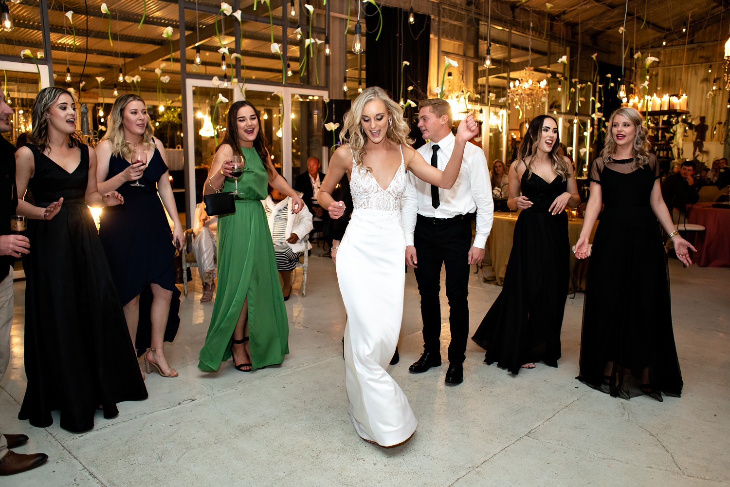 The bride dances into the middle of the circle of guests as the dancefloor opens on her wedding day. Dressed by Jason Kieck