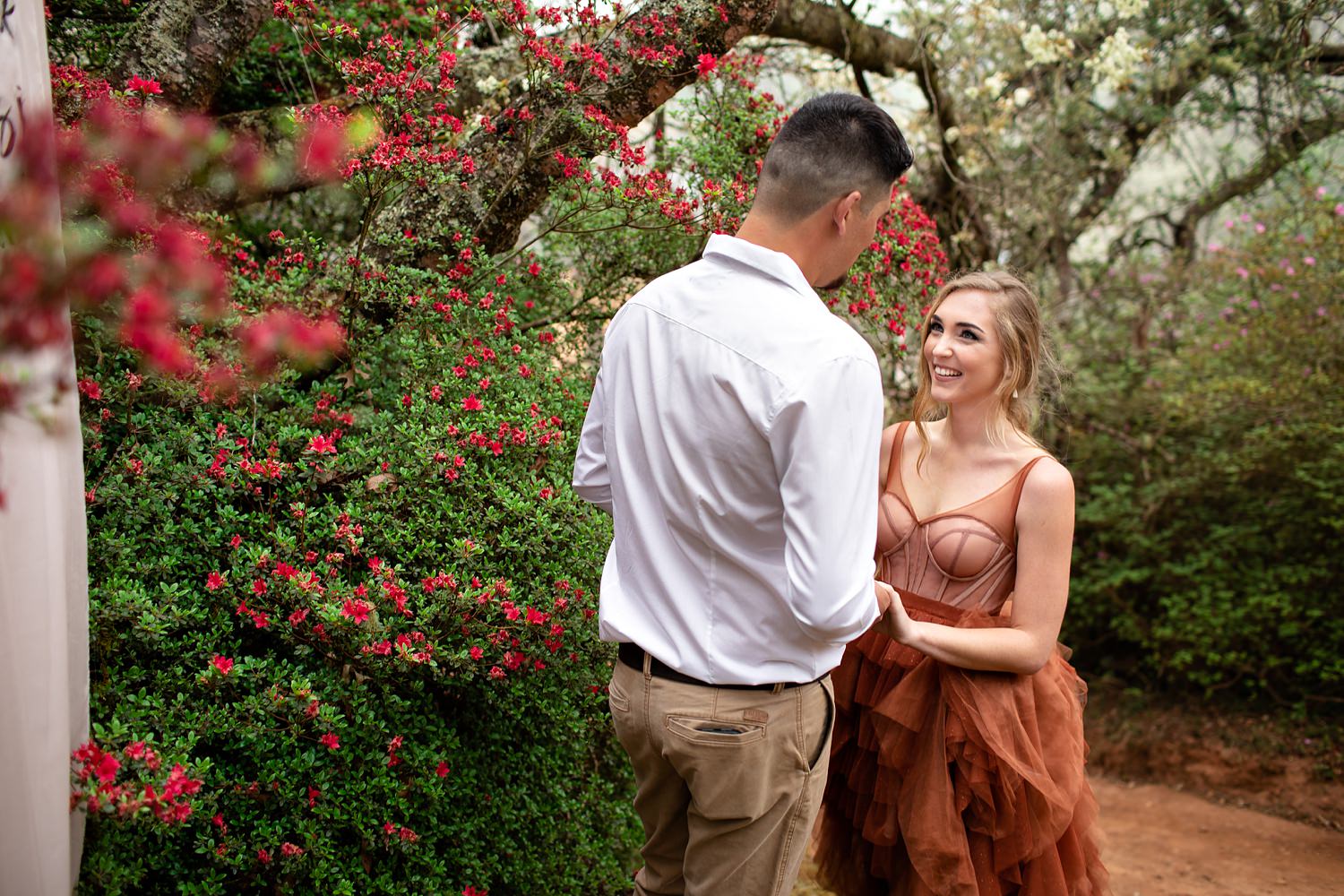 Bride and Groom exchange vows during their elopement in Magoebaskloof, surrounded by old trees and red azaleas.