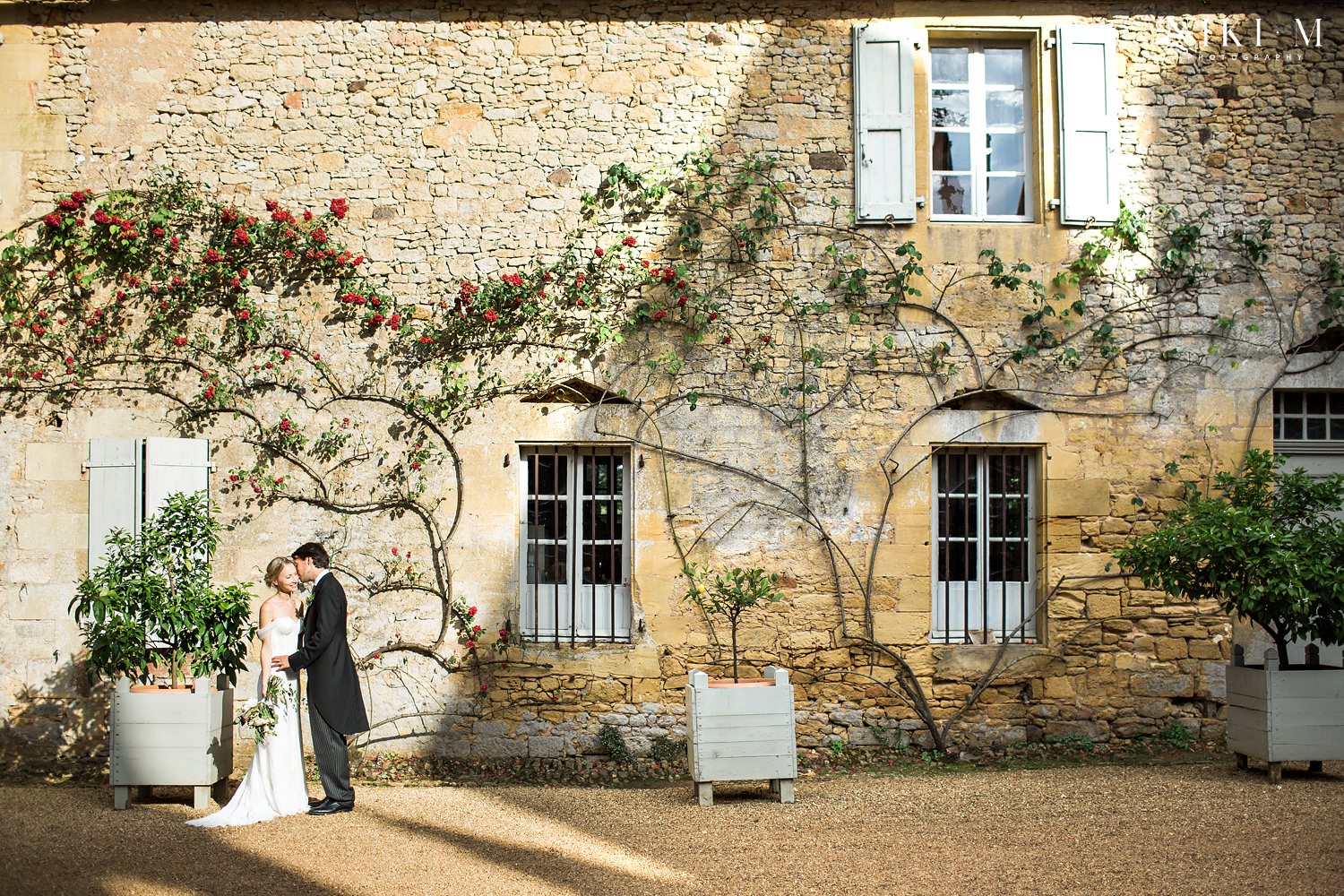 Bride and groom in the courtyard of Chateau de la Bourlie Dordogne wedding venue