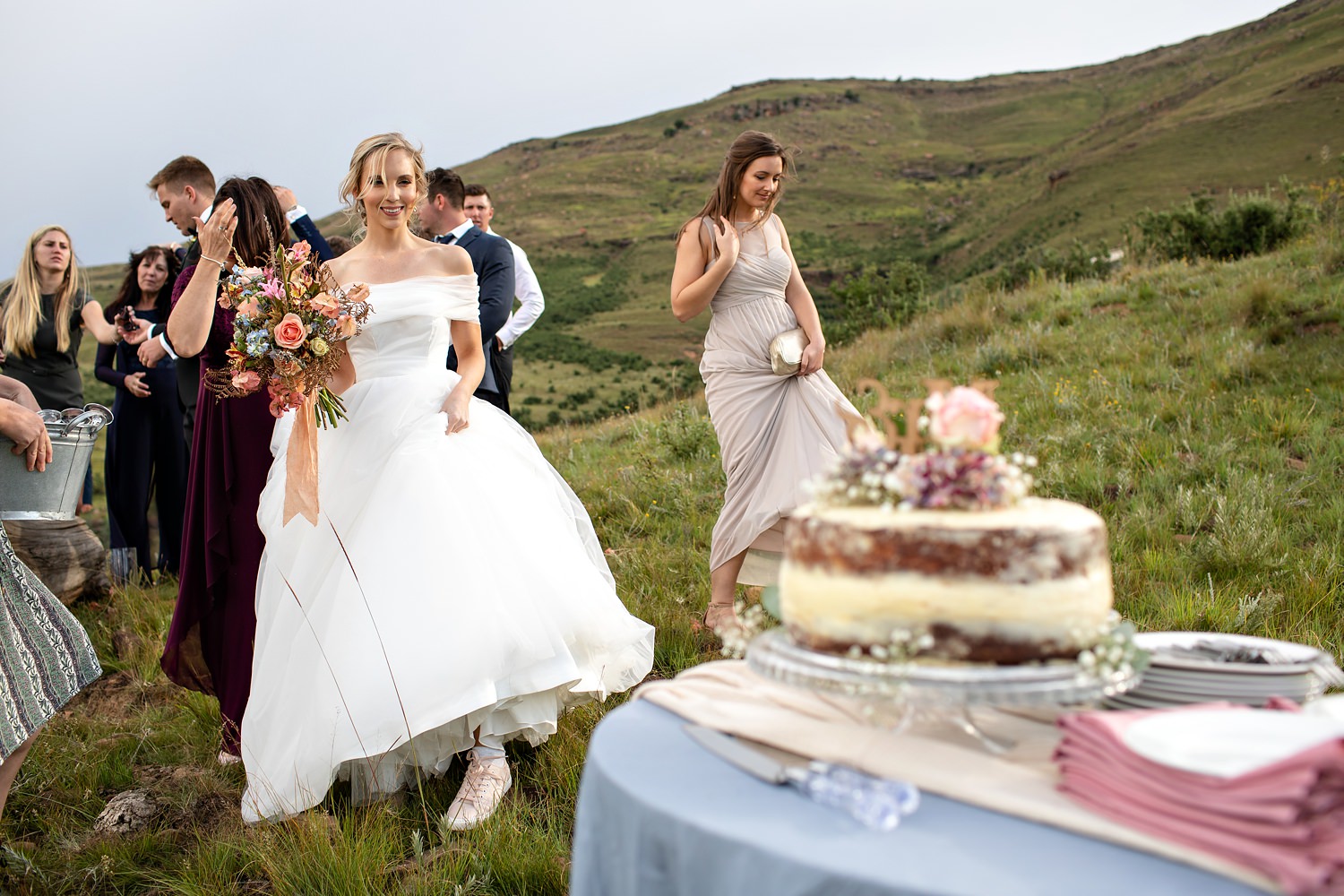 The bride looks at her cake on a mountain top in the Drakensberg.