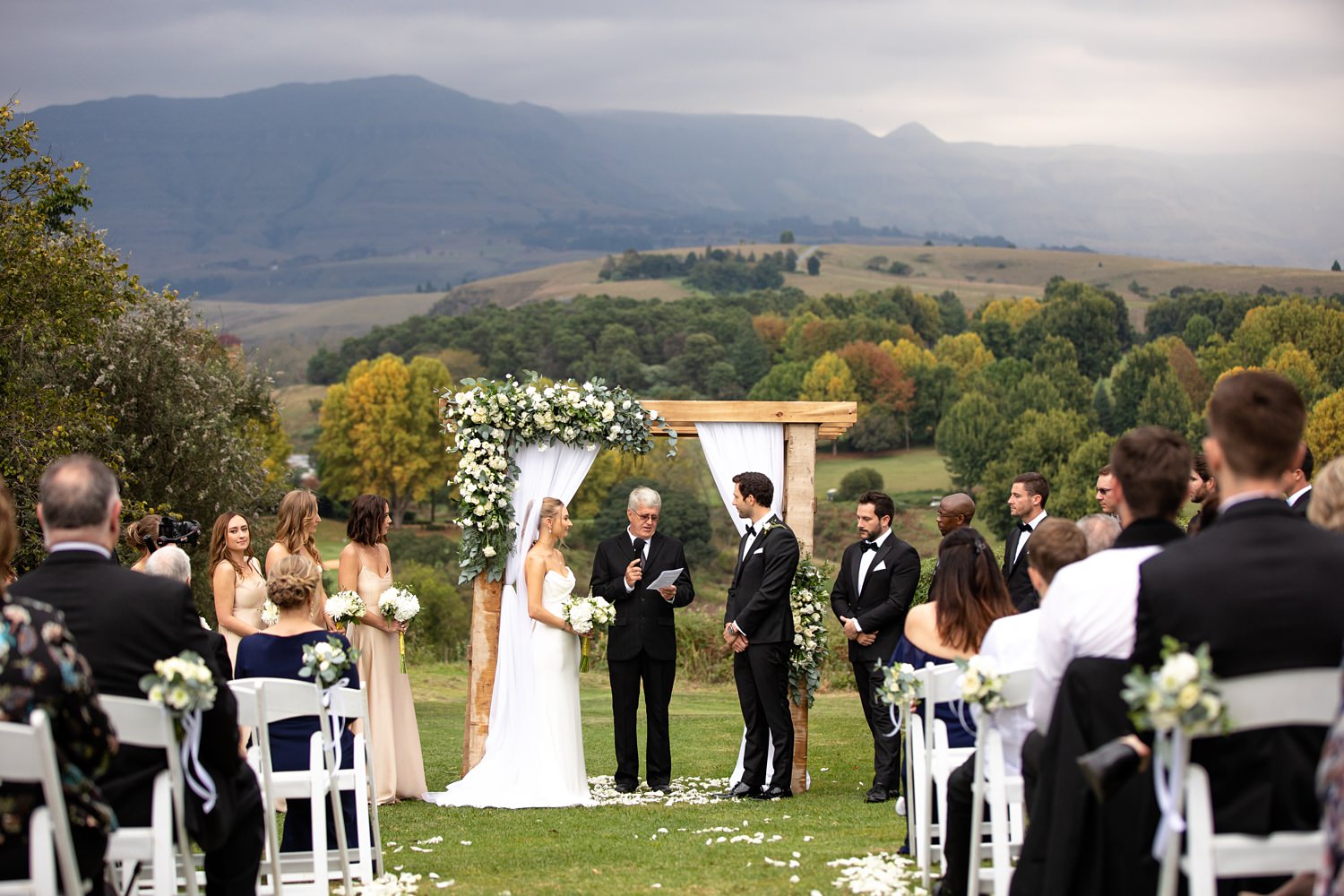 A Champagne Sports Resort wedding ceremony with Cathkin Peak in the background and dark clouds looming.