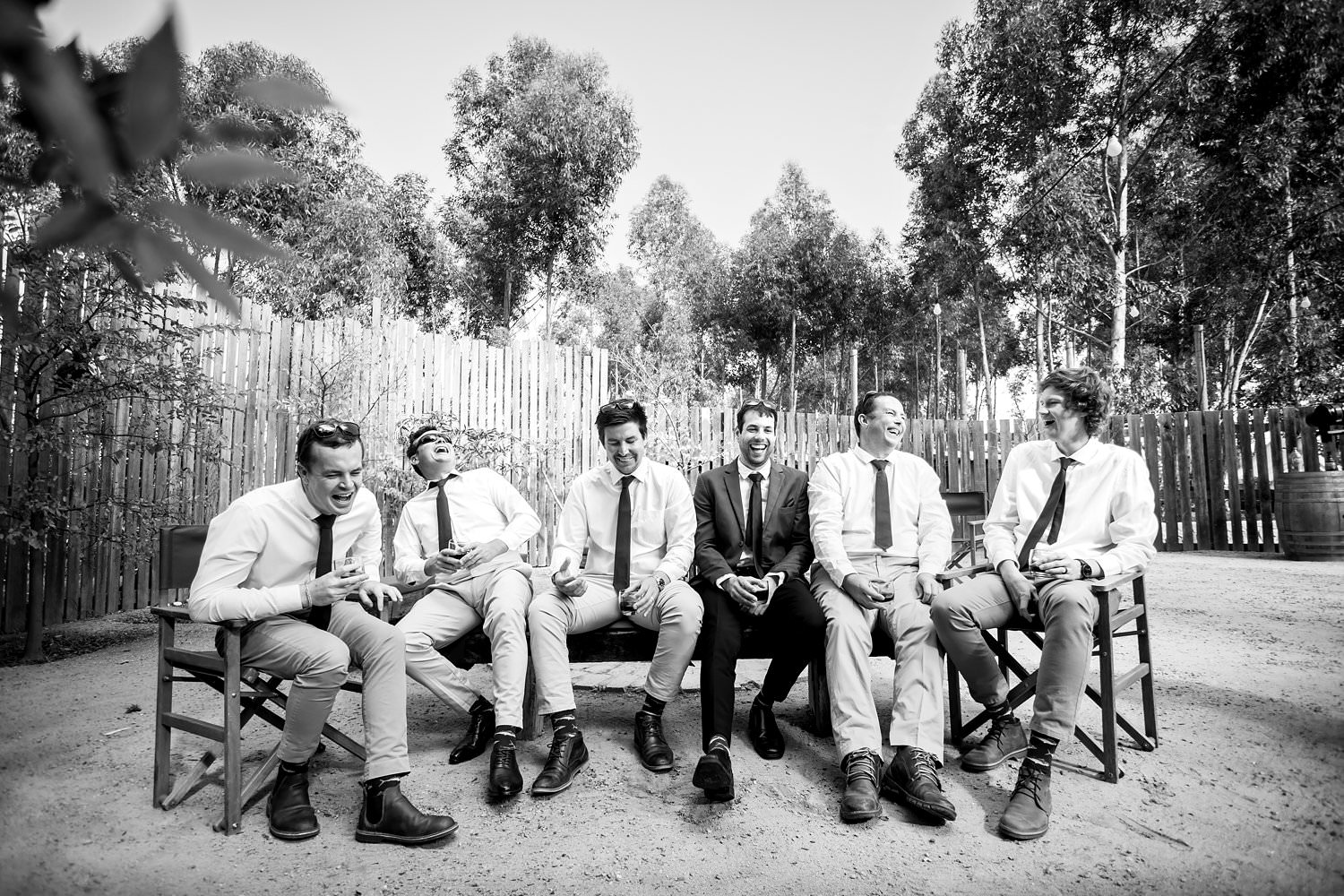 The groom and his groomsmen laugh whilst seated in the Boma at Cherry Glamping for an Elgin Wedidng