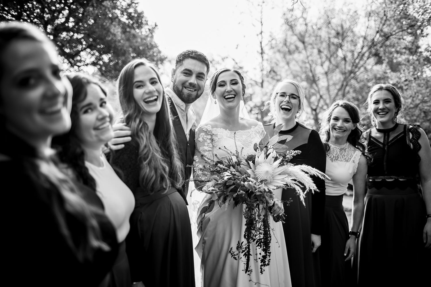 A black and white image of a laughing bride surrounded by her bridal party at a recent wedding in Elgin