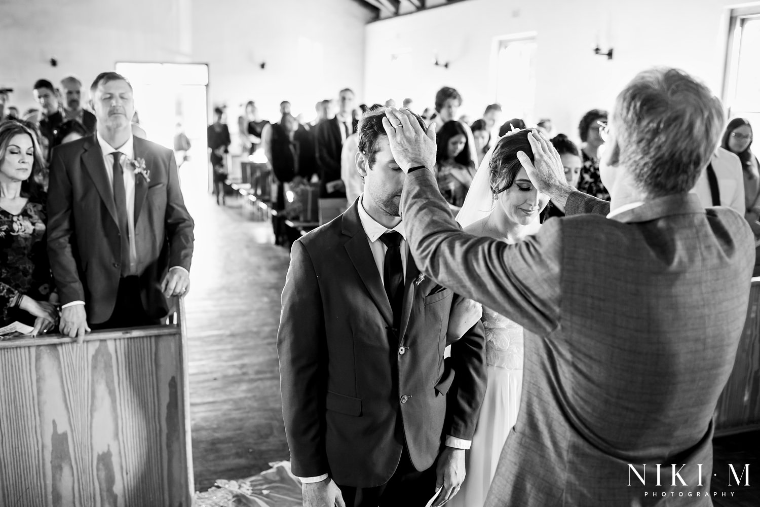 A bride and groom receive a wedding blessing during their Elgin wedding ceremony