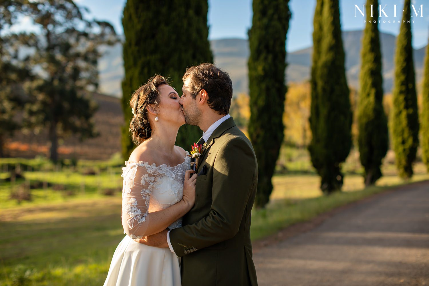 Cypress trees and the bridal couple after their ceremony at Paul Cluver Wine's chapel for their Elgin wedding