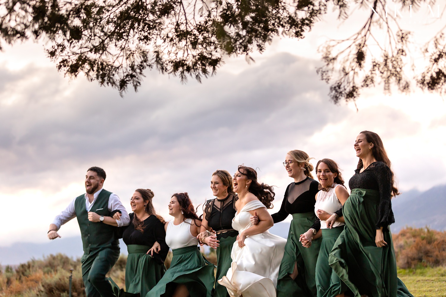 The bride skips out of frame with her bridesmaids as the sun sets behind them at an Elgin wedding.