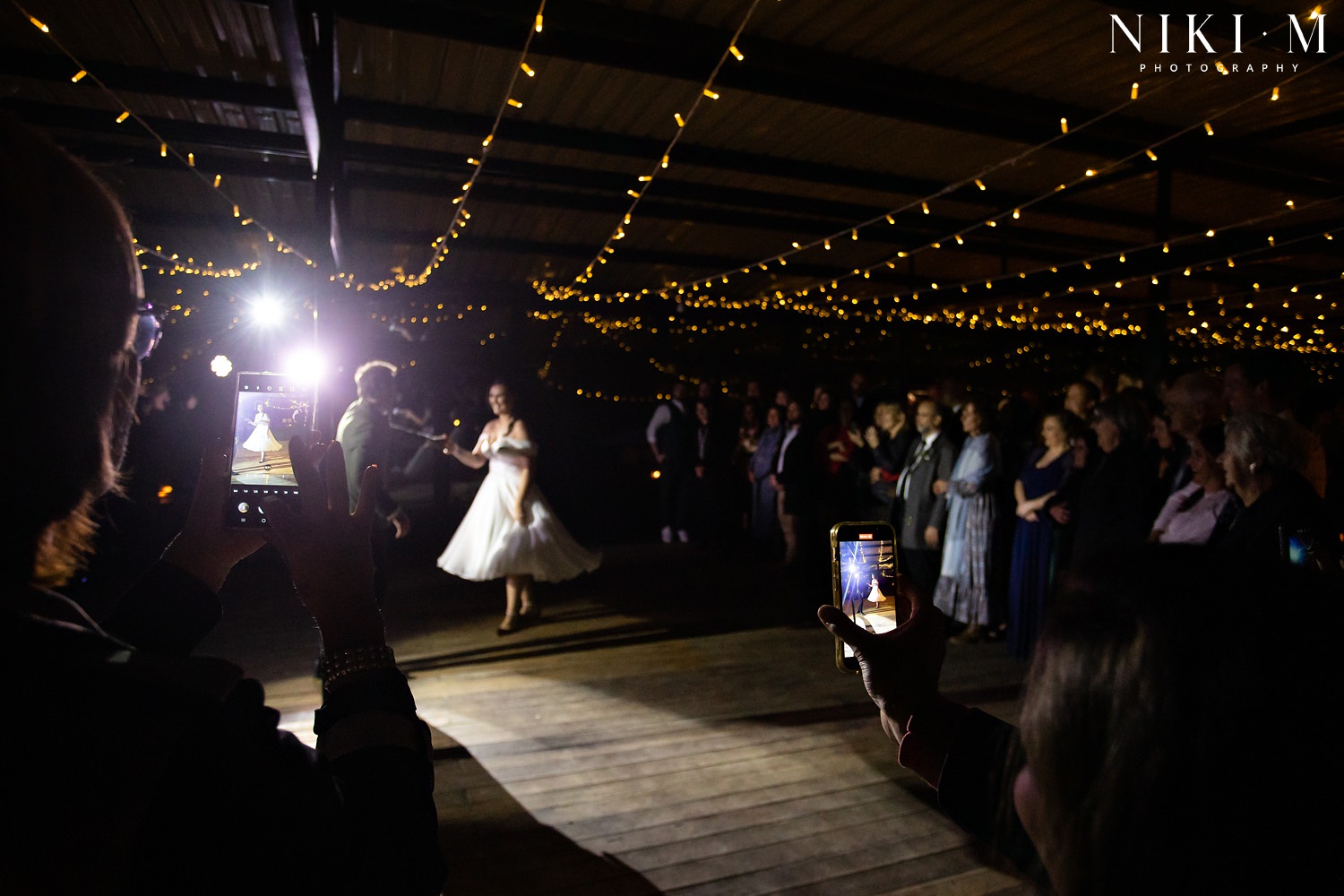 The bride and groom enter their reception venue with a dance, recorded by guests on their cellphones, at an Elgin wedding