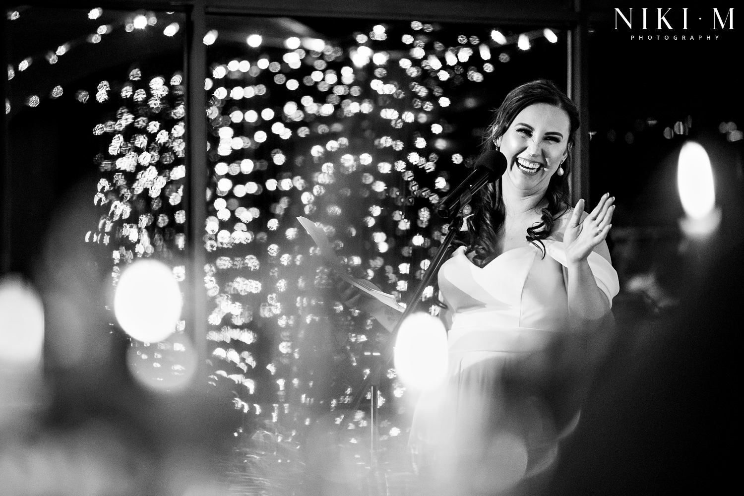 The bride makes a speech surrounded by fairy lights at her Elgin wedding venue, Cherry Glamping
