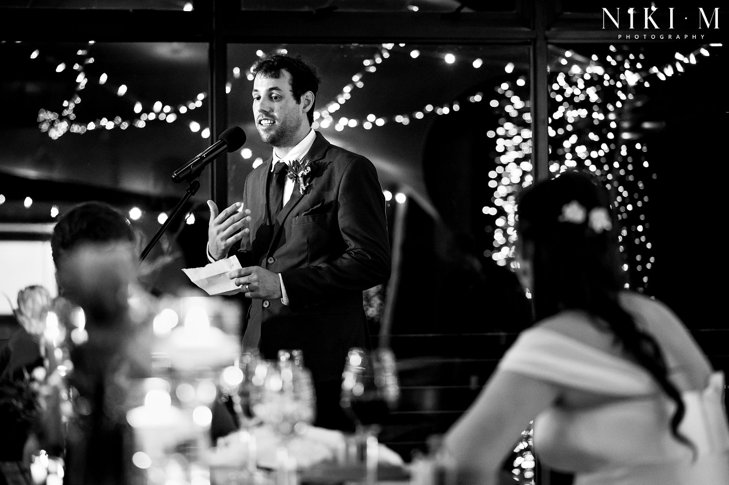 The groom makes a speech surrounded by fairy lights at his Elgin wedding venue, Cherry Glamping