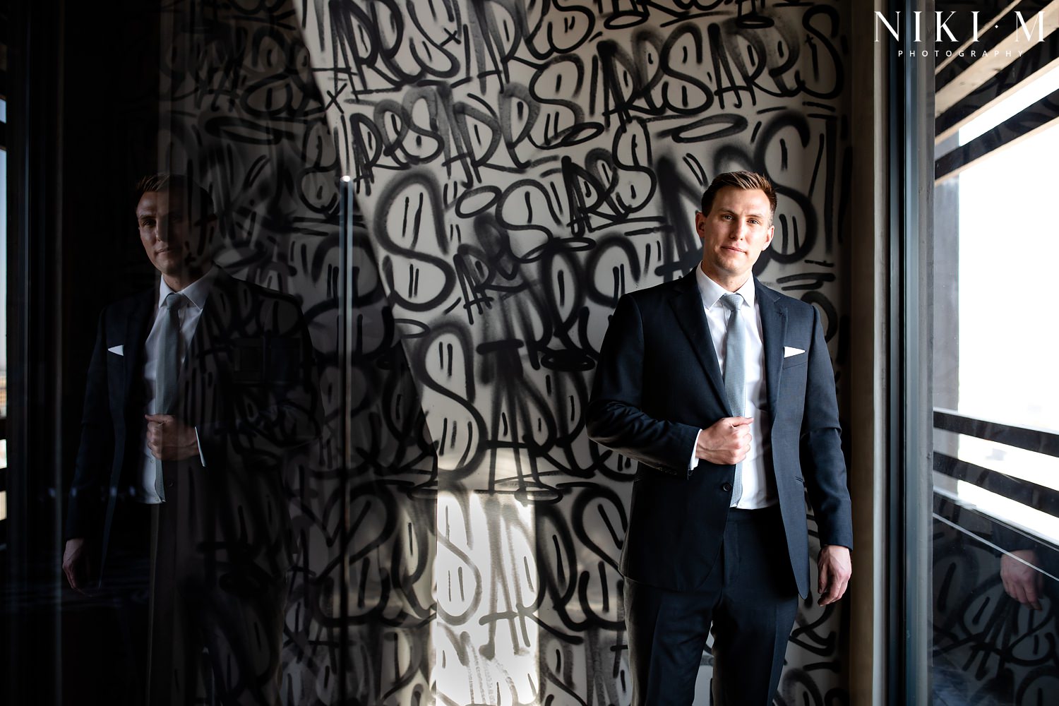 Portrait of the groom in front of spray painted wall in the Hallmark House Penthouse Suite for his Johannesburg Wedding