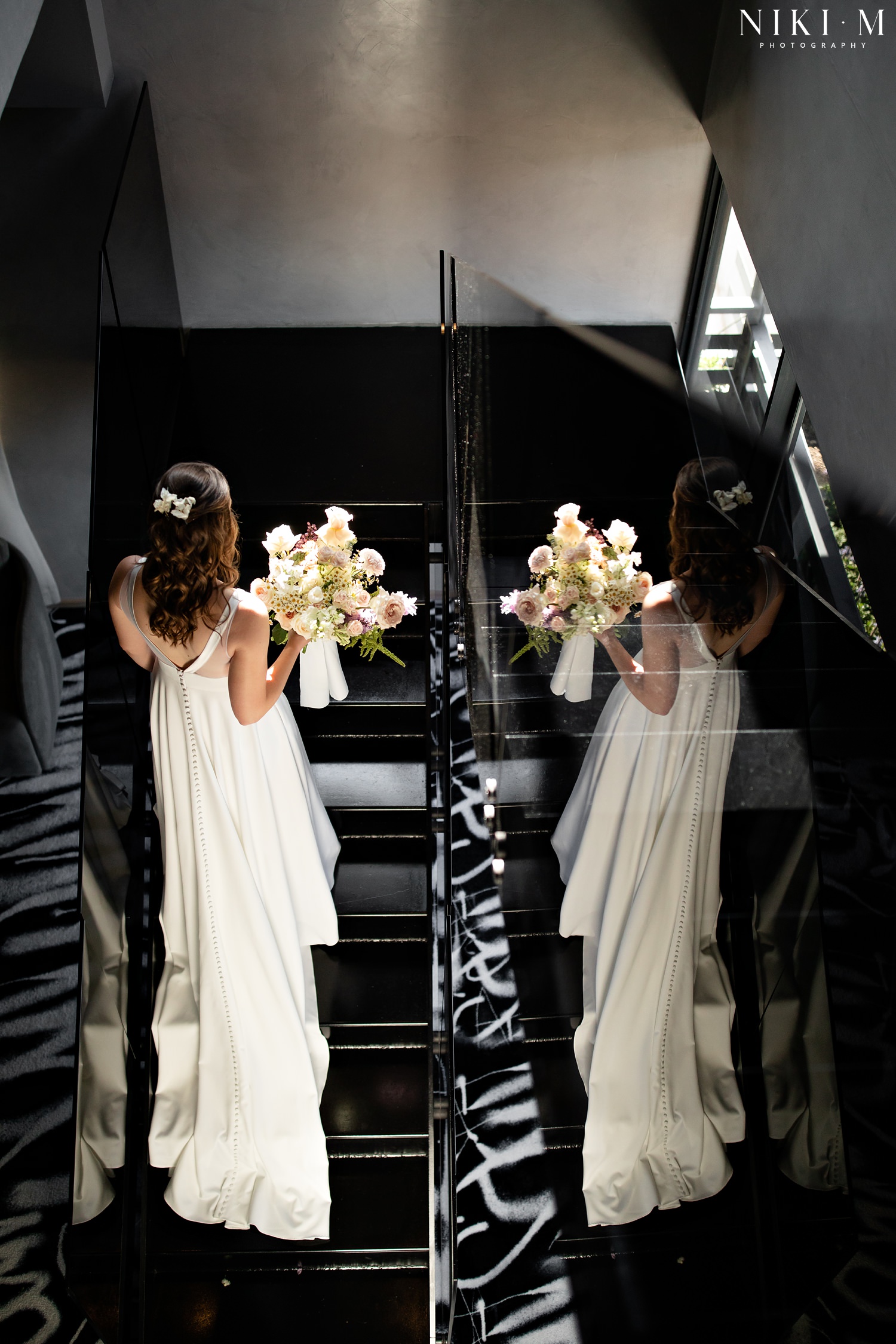 A bride walks up the stairs in the Hallmark House penthouse suite before her Johannesburg wedding