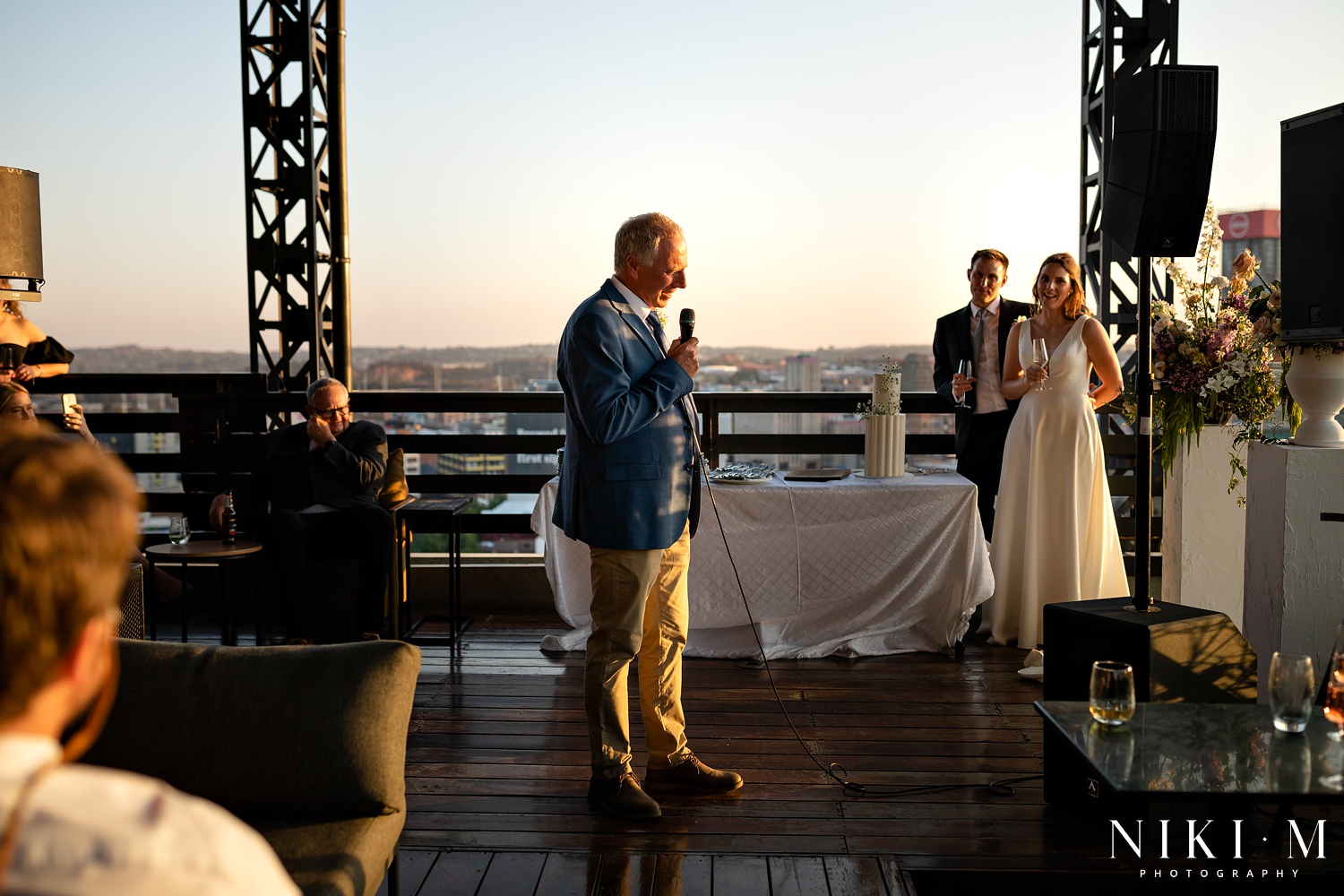 Speeches cutting overlooking the inner city skyline at a Johannesburg wedding during sunset