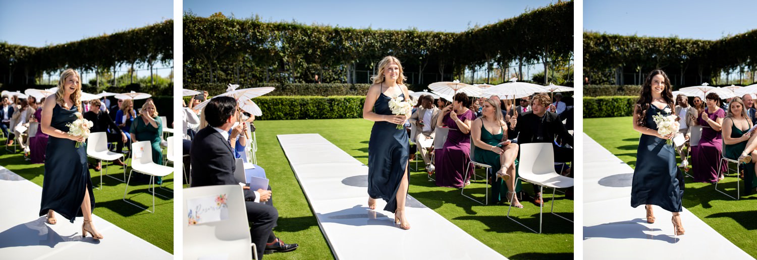 Bridesmaids enter the sunken garden at Cavalli Esate wearing navy bridesmaids dresses