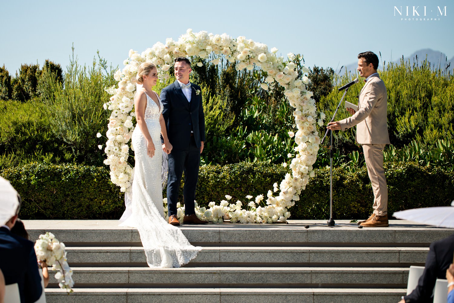 Cavalli Estate wedding in the sunken garden with white rose floral arch