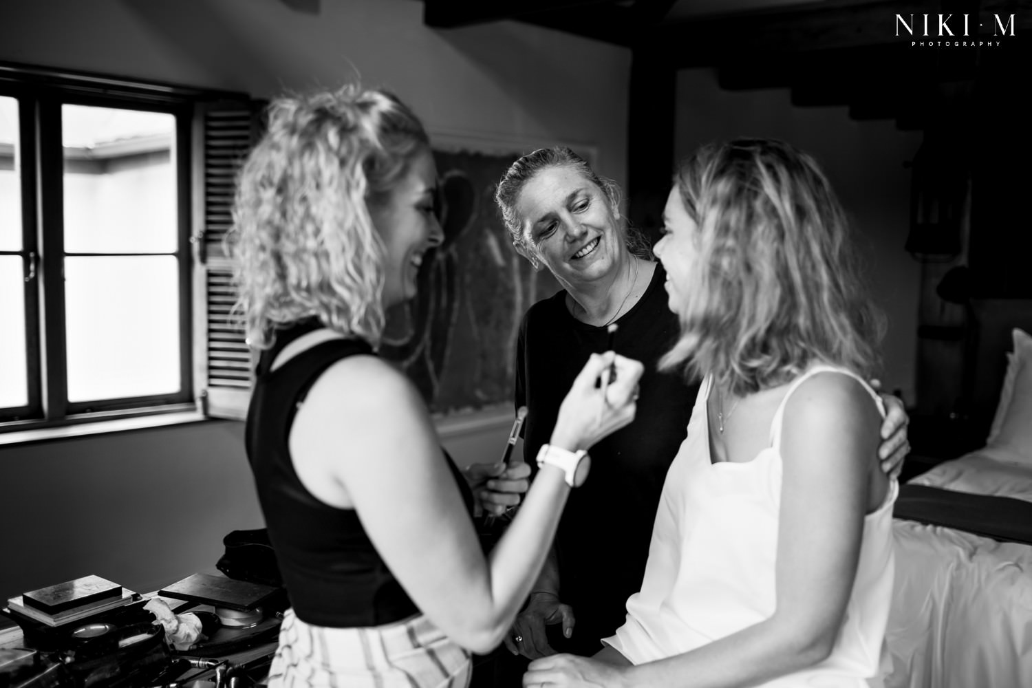 The bride's Mom comes to check up pops in during the bride's make-up session on the morning of her wedding.