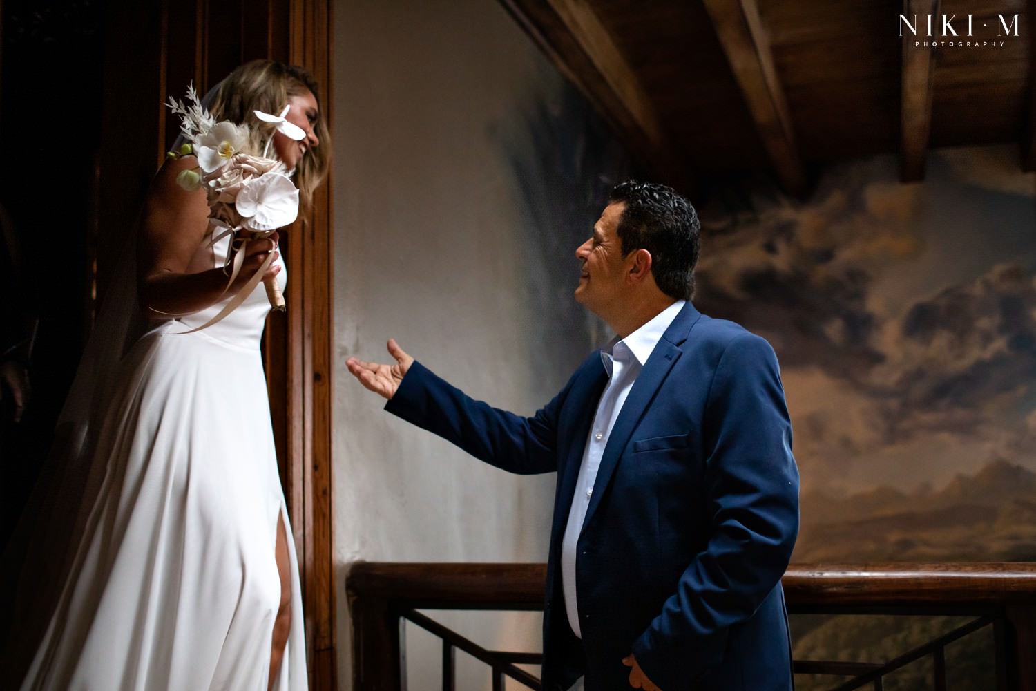 Lexi (the bride) walks towards her father with his outstretched hand, as he prepares to walk her down the aisle.