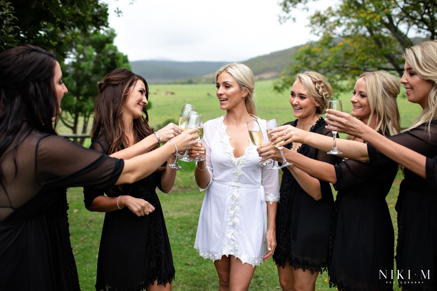 Garden Route wedding venue Kay and Monty. Bride and her bridesmaids cheers with champagne.