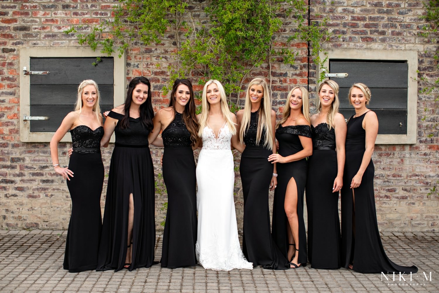 Bridesmaids dressed in black surround the bride