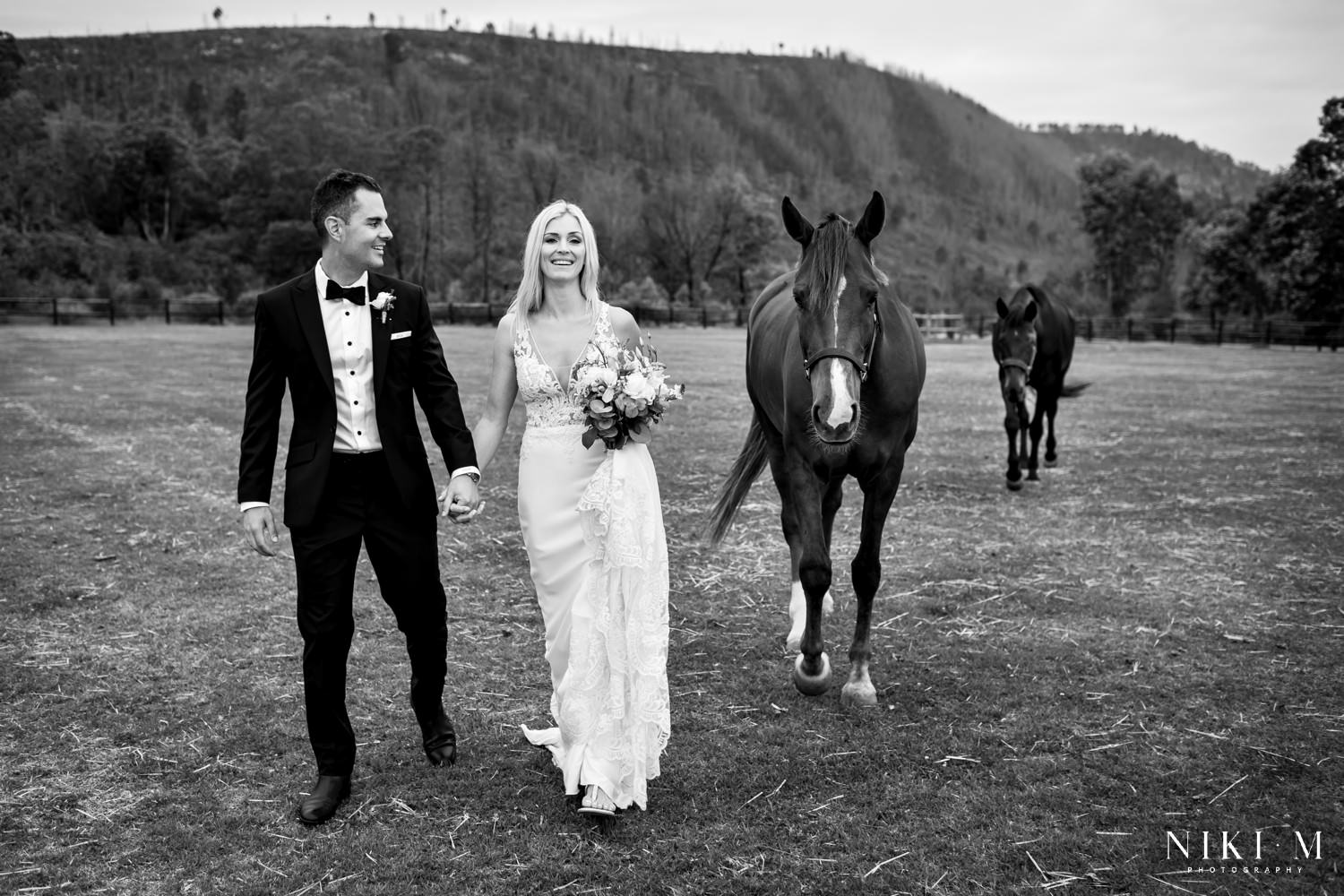 Wedding photos with horses. The bride and groom walk alongside their horses during their portrait session.