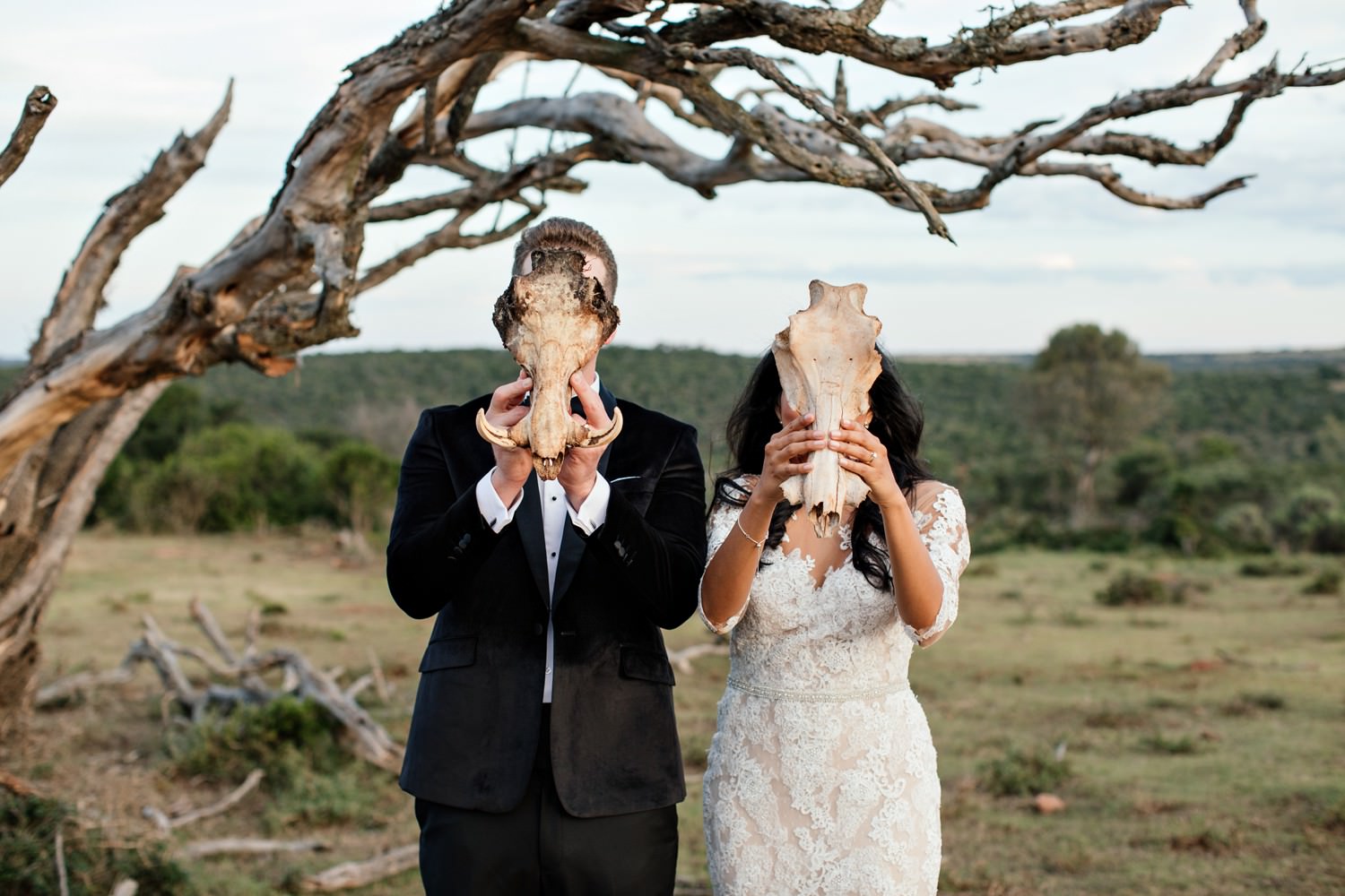 Bride and Groom cover their faces with animal skulls found at Pumba Lodge in the Eastern Cape of South Africa. Image by safari photographer Niki M 