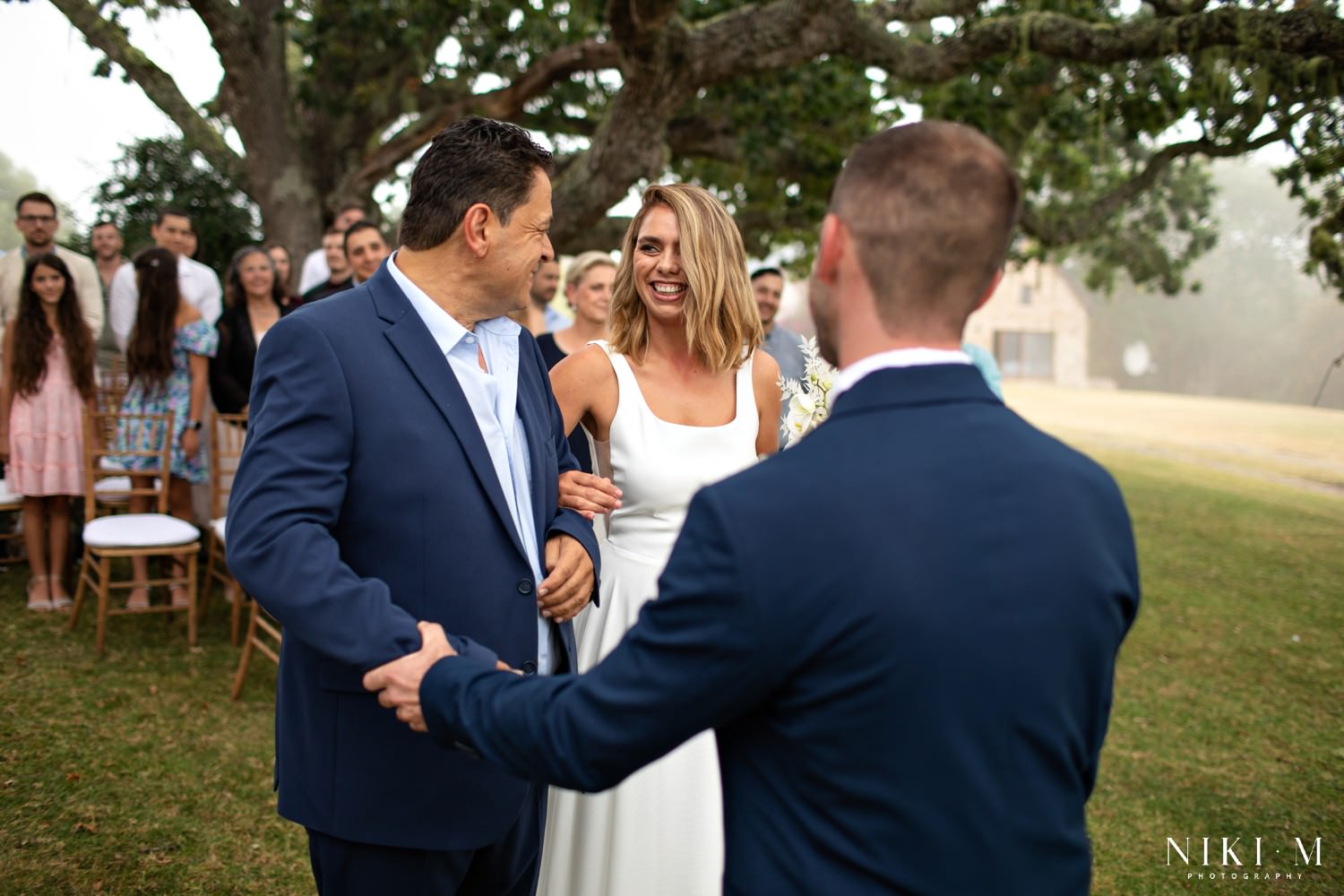 The bride's father gives her away at the top of the aisle.