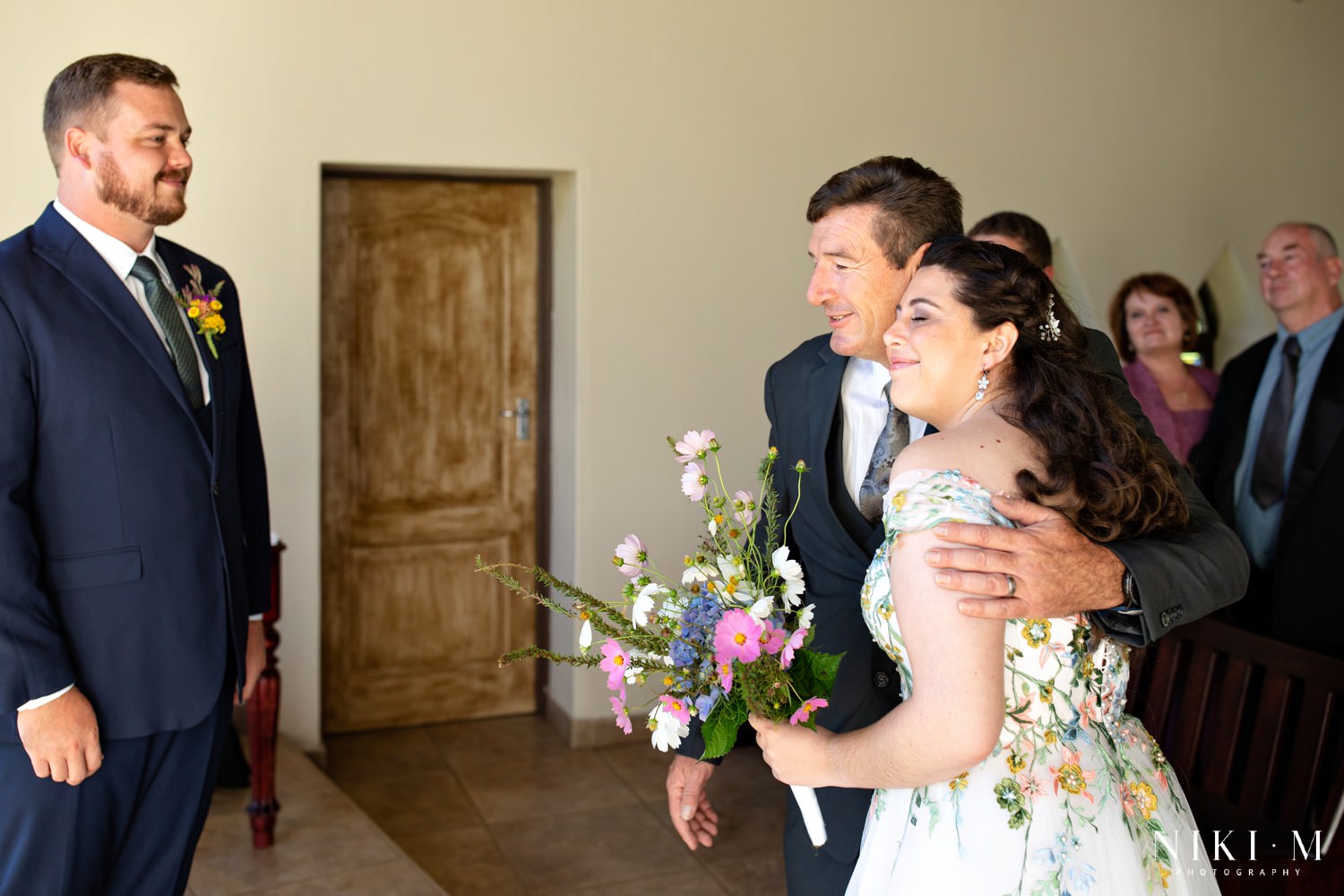 Father embraces his daughter as he gives her away, moments before the ceremony begins, inside the cosy mountain chapel at Champagne Castle Hotel.