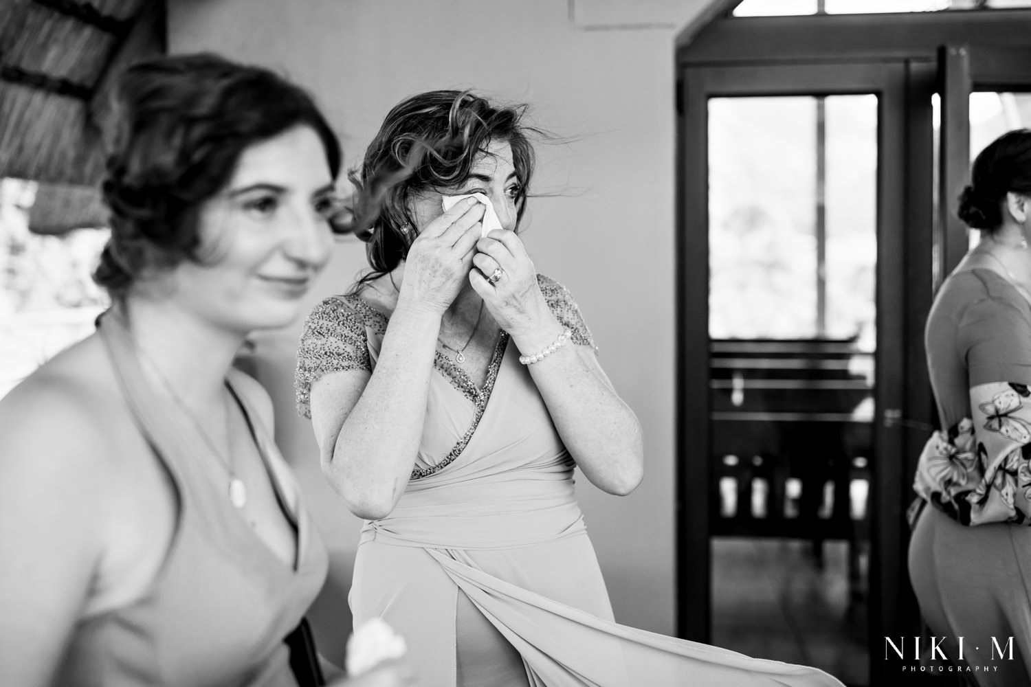 A tearful mother wipes her eyes as emotions overflow during the intimate vows at a Central Drakensberg wedding ceremony filled with love and family connection.