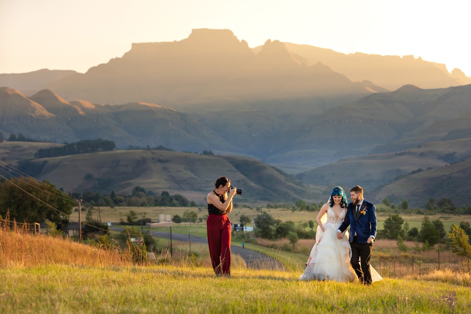 Newlyweds sharing a moment during their photography session with Niki M in the Central Drakensberg at sunset. It's a breathtaking view that defines Drakensberg wedding venues. The warm golden light and endless mountain layers create a cinematic setting for timeless wedding photography.