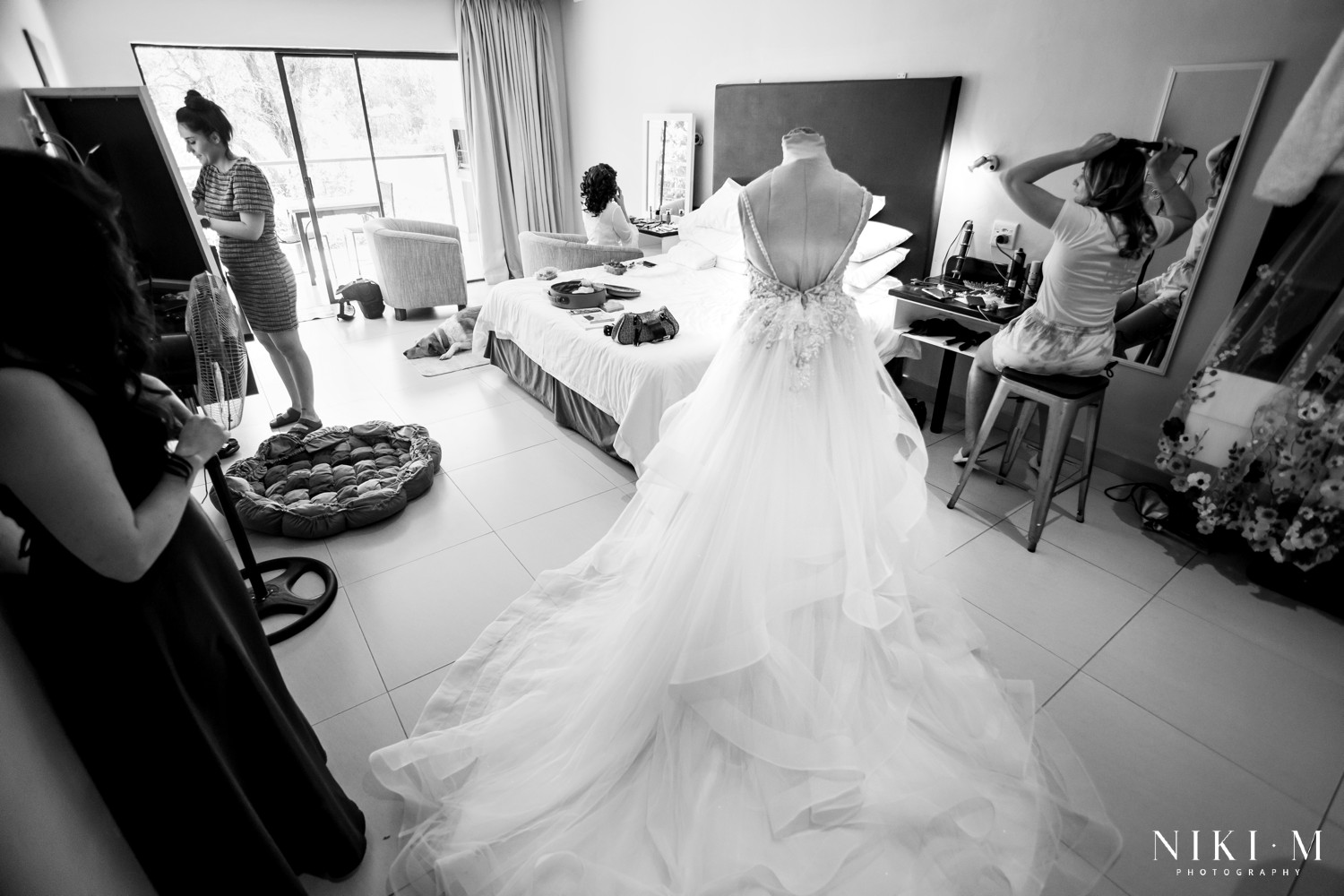 Bridal suite with Nicole Milano gown on mannequin and bridesmaids getting ready, Drakensberg wedding photographer