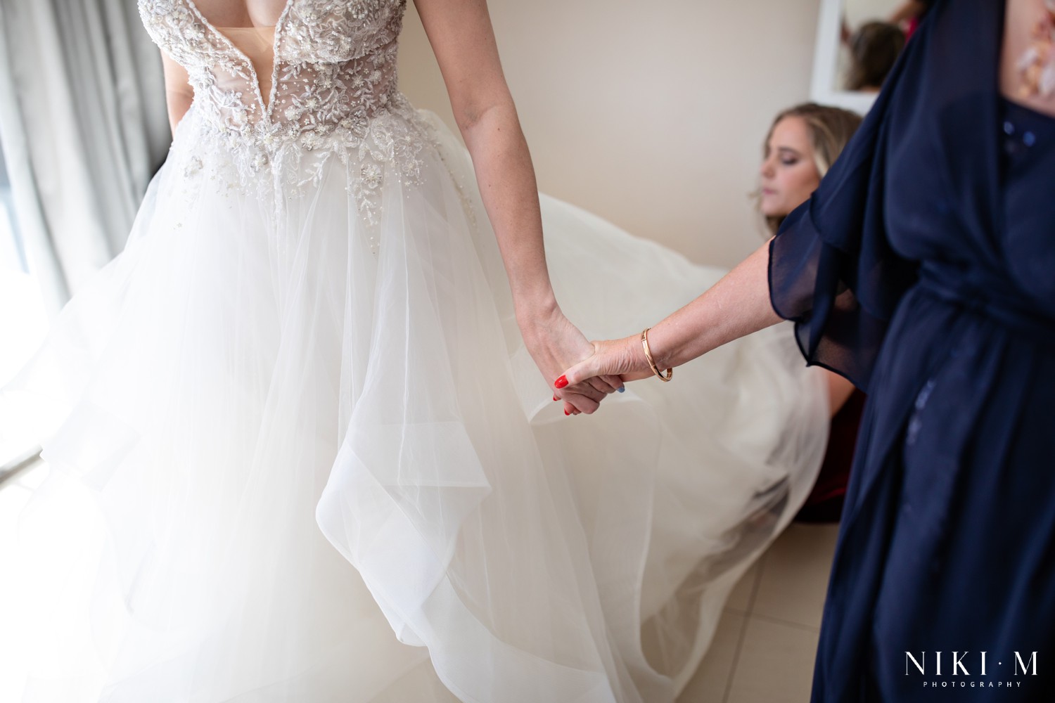 Mother of the bride holding her daughter's hand, captured by Drakensberg wedding photographer Niki M