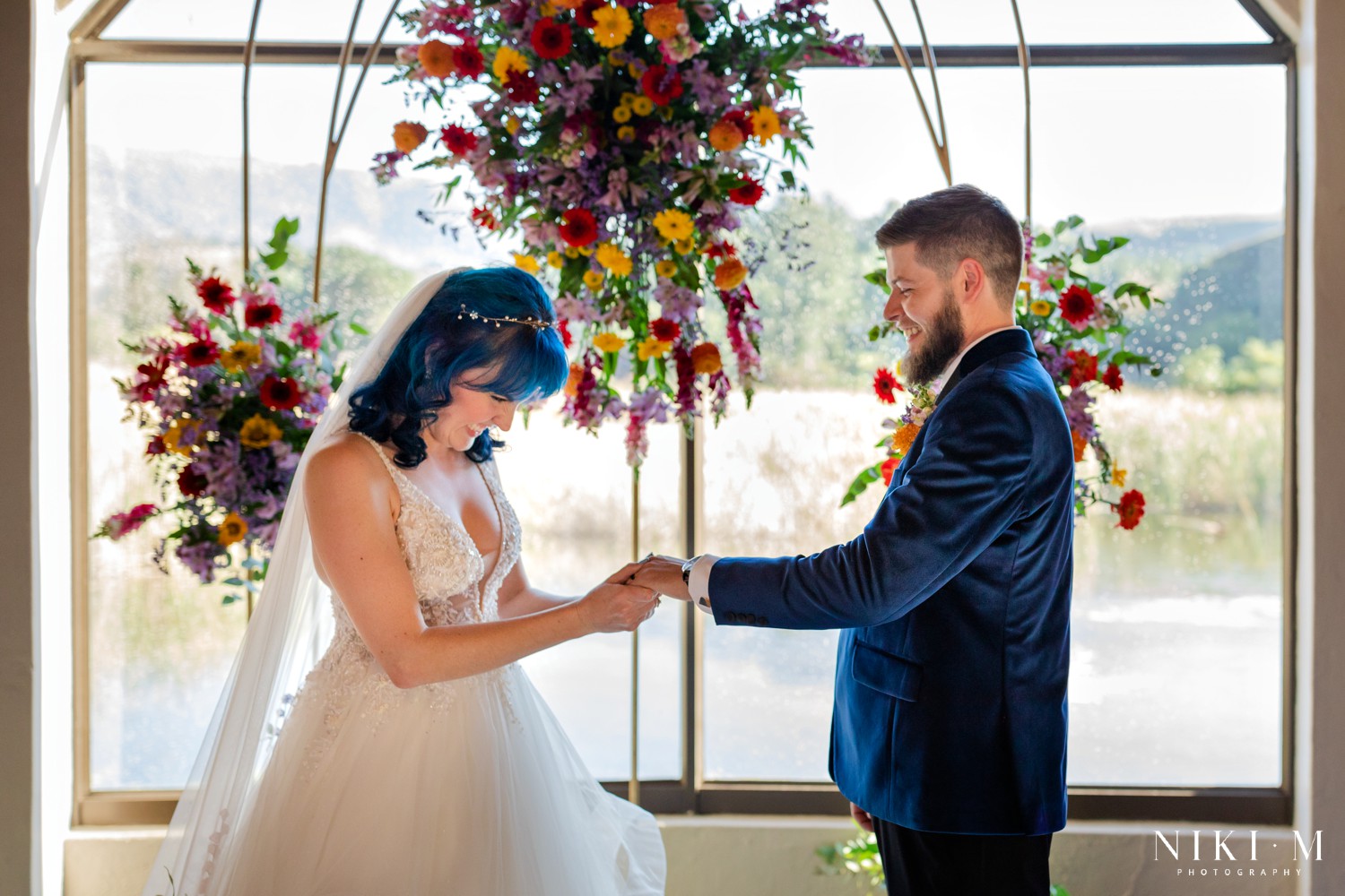 Ring exchange with the Drakensberg lake and mountains through the chapel window at a Champagne Valley wedding