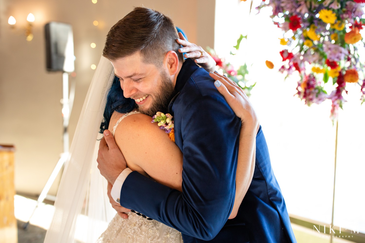 Groom holding his bride close and laughing after the ceremony at a Drakensberg wedding in Champagne Valley