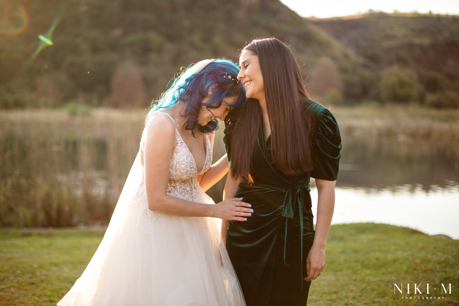 Bride and bridesmaid laughing forehead to forehead at golden hour at a Champagne Valley Drakensberg wedding