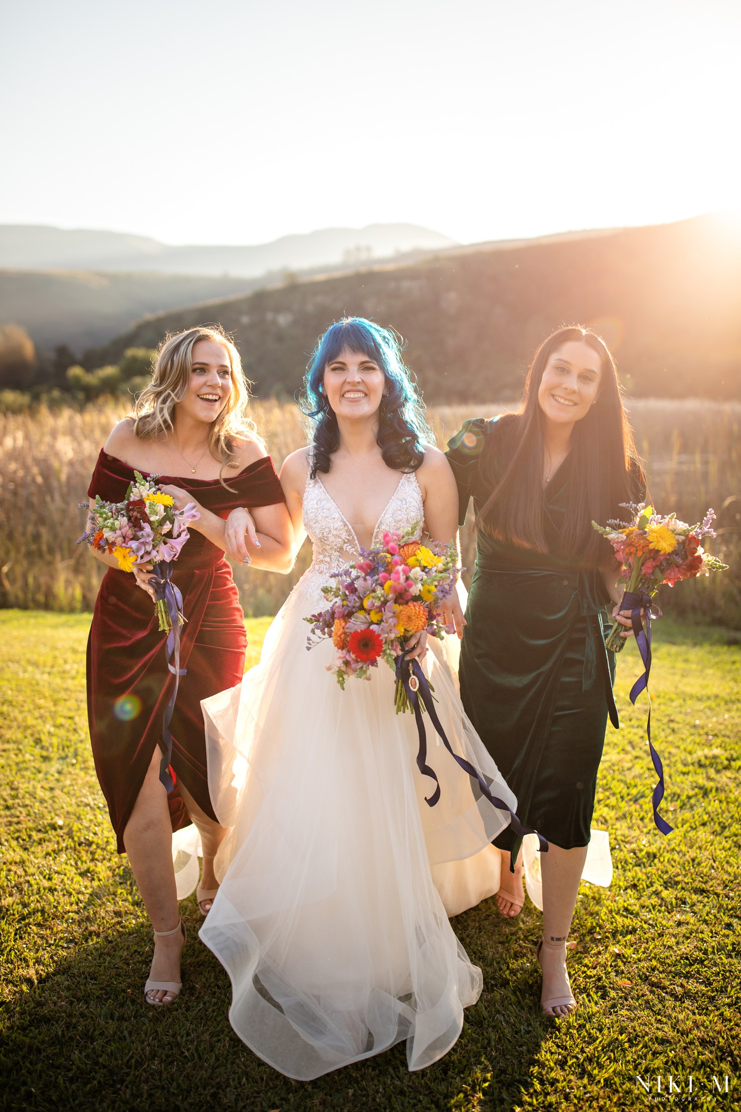 Bride with her bridesmaids at golden hour with the Drakensberg mountains behind them, Champagne Valley wedding photographer