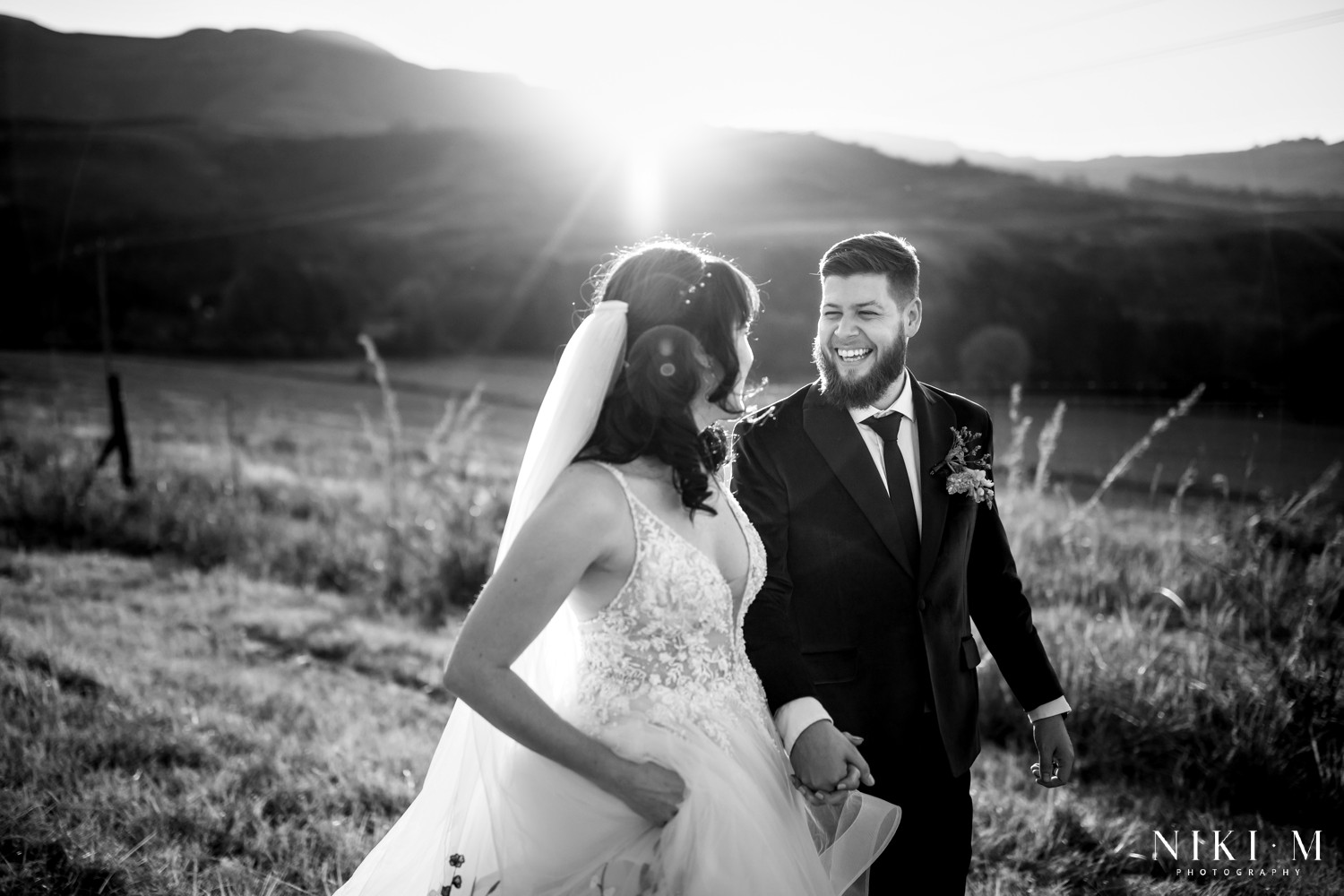 Black and white couple portrait with the Drakensberg mountain silhouette and golden sunset behind them