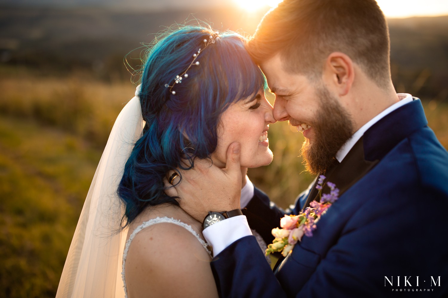 Bride and groom forehead to forehead with Drakensberg mountain grasslands stretching behind them, Champagne Valley wedding