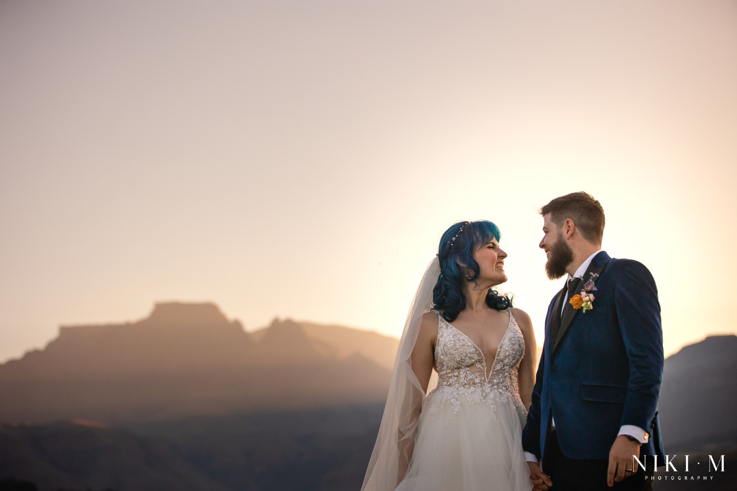 Bride and groom silhouetted against the Drakensberg escarpment at sunset, Champagne Valley wedding photographer