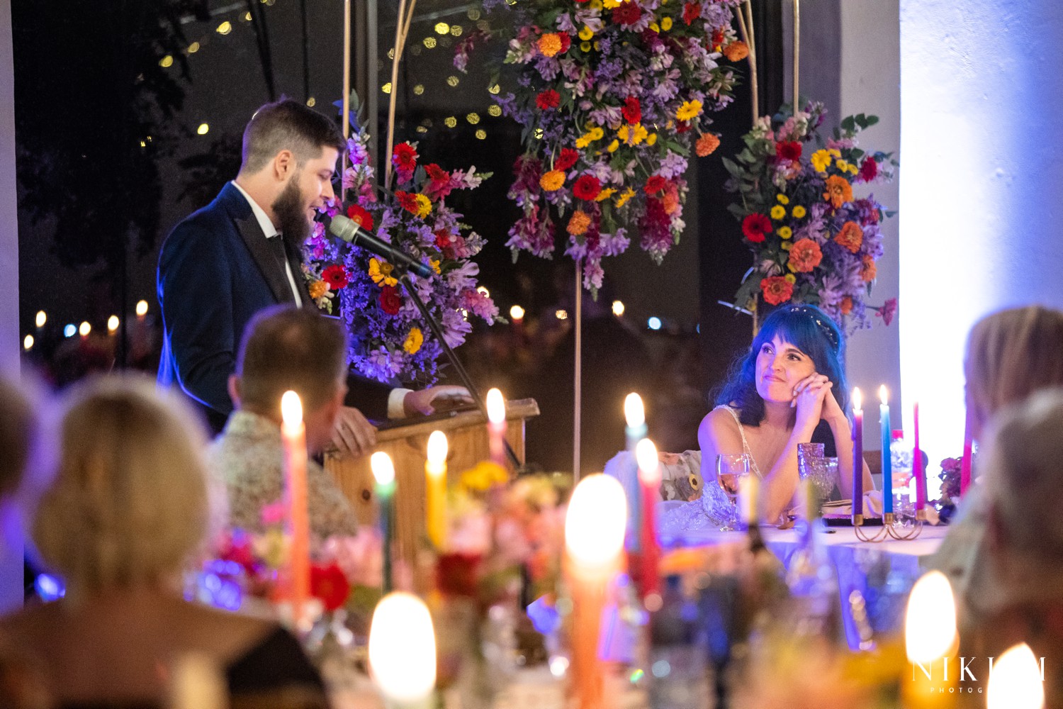 Groom giving his speech with candles glowing in the foreground at a Drakensberg wedding reception