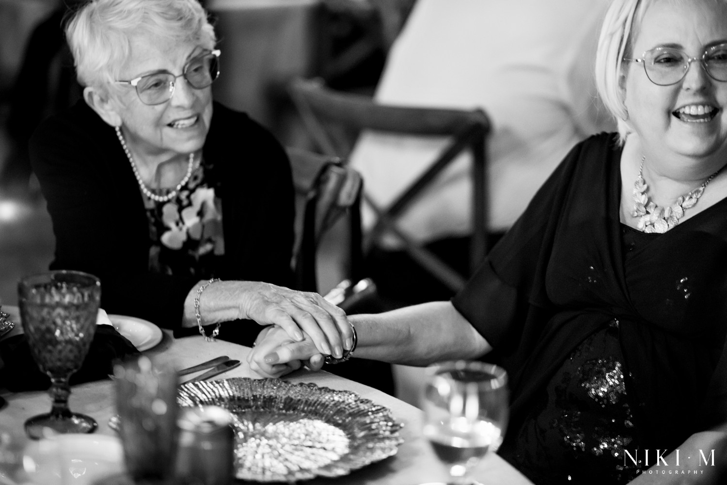 Black and white portrait of the grandmother and mother of the bride laughing together at a Drakensberg wedding reception