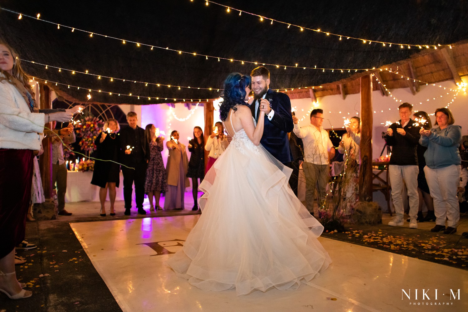 Bride and groom dancing close during their first dance with sparklers glowing all around them, Champagne Valley wedding