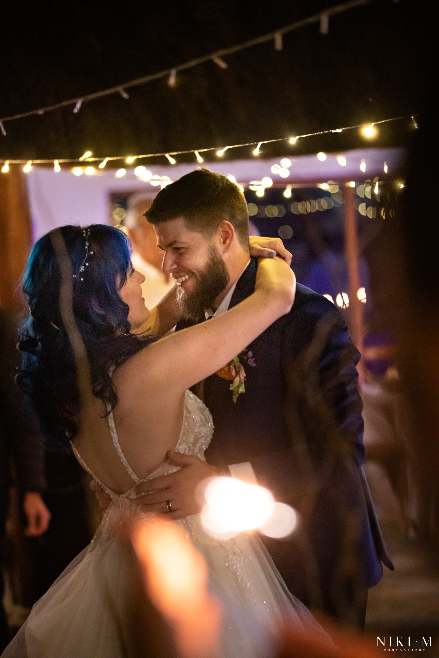 First dance with fairy lights and a wildflower arch glowing in the background at a Drakensberg wedding